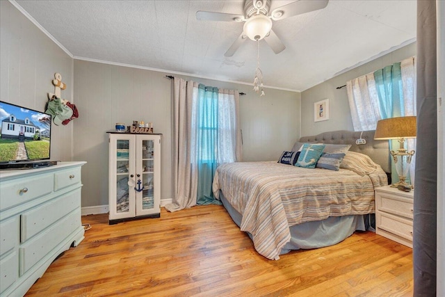 bedroom featuring multiple windows, ceiling fan, and light wood-type flooring