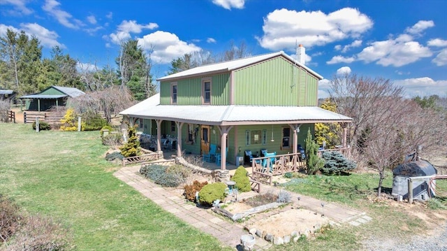 back of house with a yard, covered porch, and a chimney