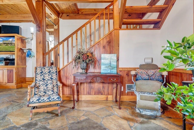 stairs featuring wood walls, wood ceiling, and beam ceiling