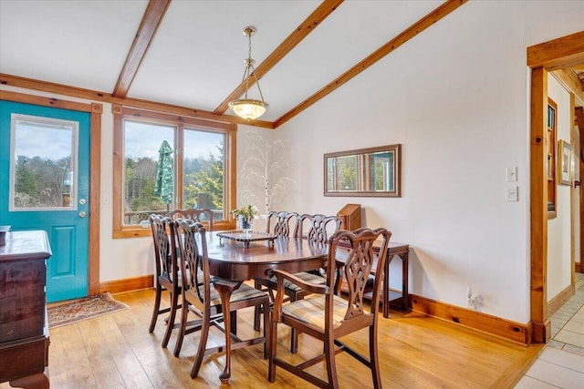 dining space featuring lofted ceiling with beams and light hardwood / wood-style floors