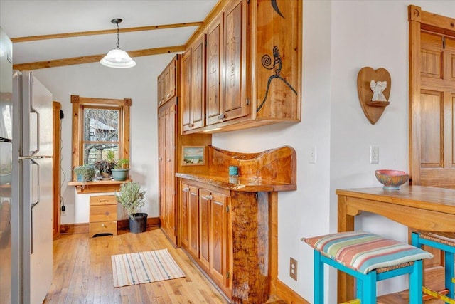hall featuring light wood-type flooring, baseboards, and lofted ceiling