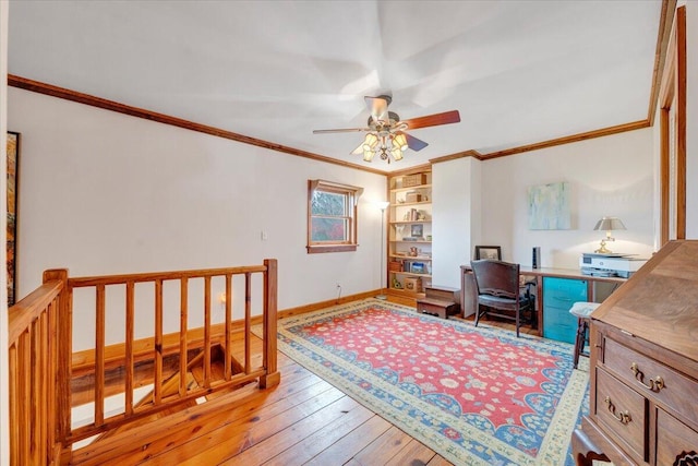 office with built in shelves, ceiling fan, ornamental molding, and light wood-type flooring