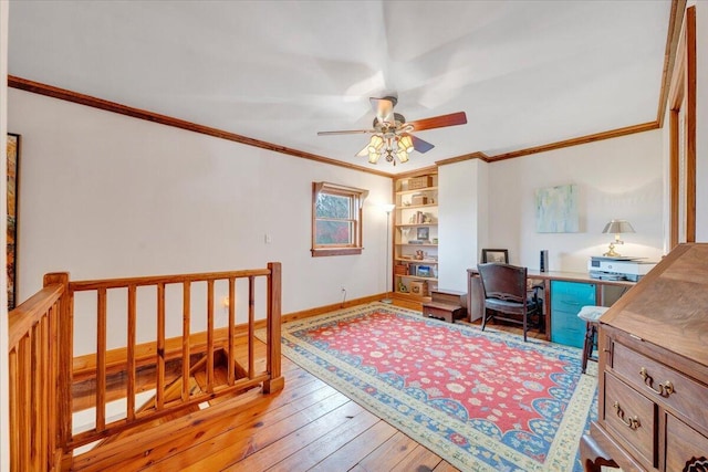 office area featuring hardwood / wood-style floors, baseboards, crown molding, and a ceiling fan