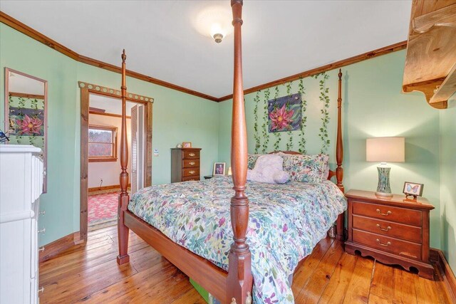 bedroom with crown molding, a closet, baseboards, and hardwood / wood-style floors