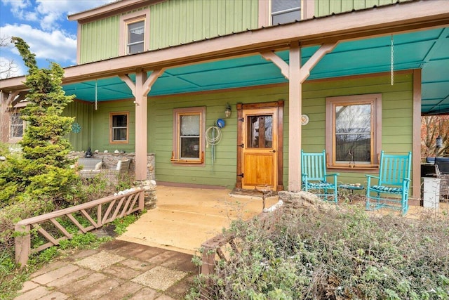 entrance to property with board and batten siding and a porch