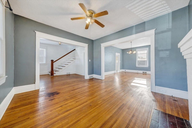 unfurnished living room featuring a textured ceiling, ceiling fan with notable chandelier, and hardwood / wood-style flooring