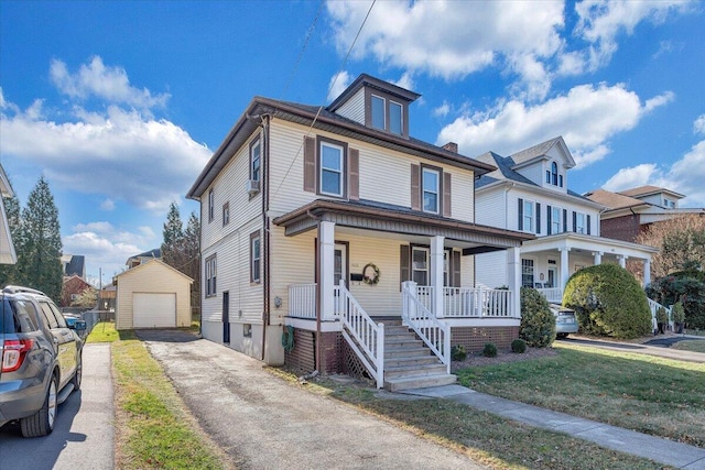 view of front of home featuring a porch, a garage, an outdoor structure, and a front lawn