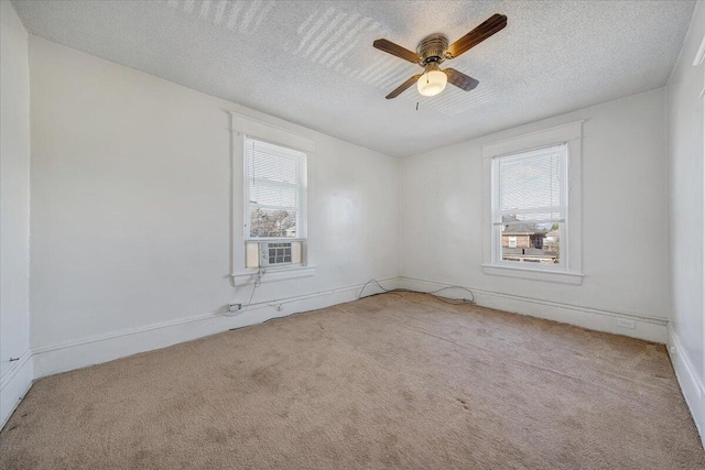 spare room featuring ceiling fan, light carpet, and a textured ceiling