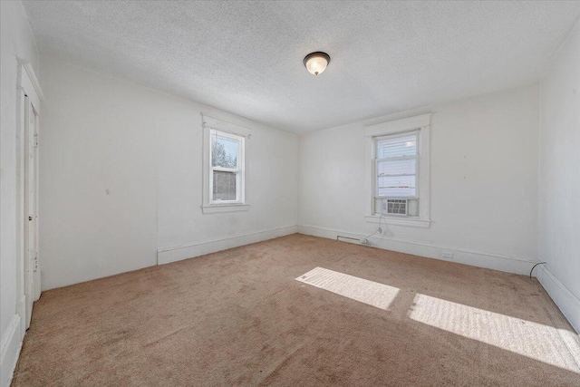 empty room with light colored carpet and a textured ceiling