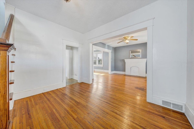 empty room featuring a textured ceiling, hardwood / wood-style flooring, and ceiling fan