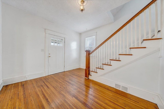 foyer featuring wood-type flooring and a textured ceiling