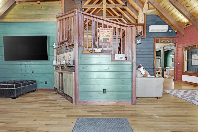 living room with wood walls, lofted ceiling with beams, light hardwood / wood-style flooring, wooden ceiling, and radiator