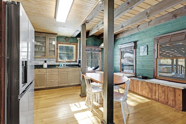 kitchen featuring wood walls, stainless steel fridge with ice dispenser, wooden ceiling, beamed ceiling, and light hardwood / wood-style floors