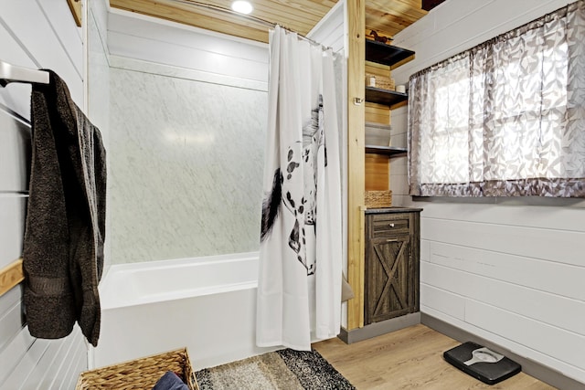 bathroom with shower / tub combo, wood-type flooring, and wood walls