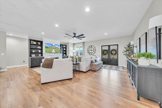 living room featuring ceiling fan, light hardwood / wood-style floors, and french doors