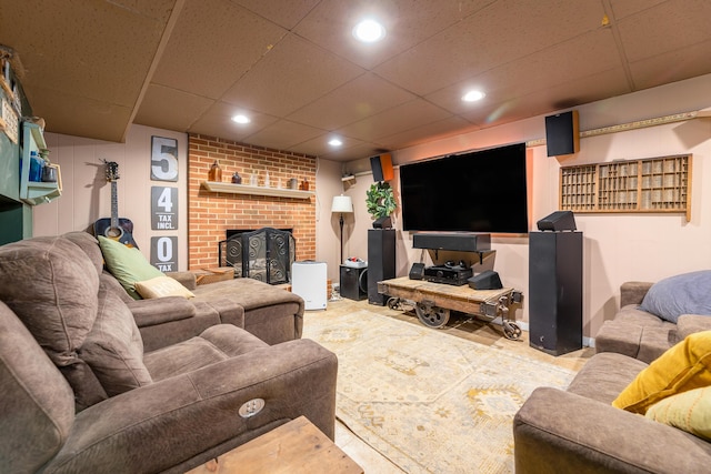 living room featuring a brick fireplace and a paneled ceiling