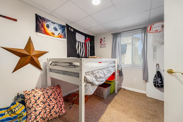 bedroom featuring carpet floors and a drop ceiling