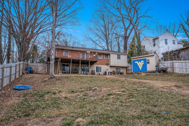 rear view of property featuring a shed, a wooden deck, and a yard