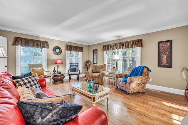 living room featuring hardwood / wood-style flooring, a wealth of natural light, and ornamental molding