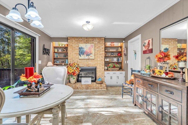 dining room featuring built in shelves, crown molding, and a brick fireplace