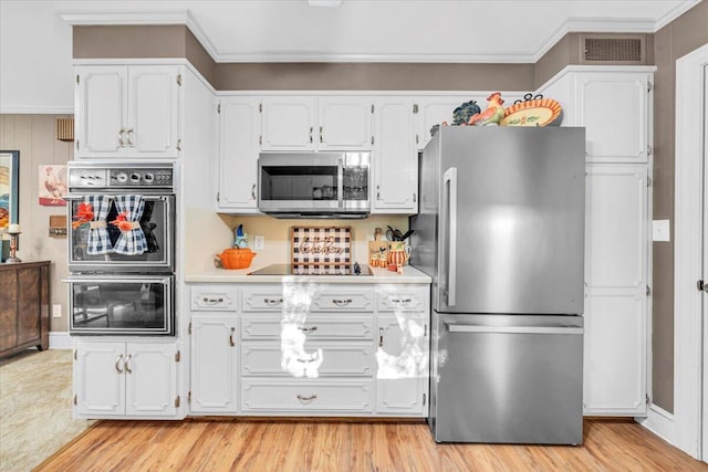 kitchen with crown molding, white cabinets, black appliances, and light wood-type flooring