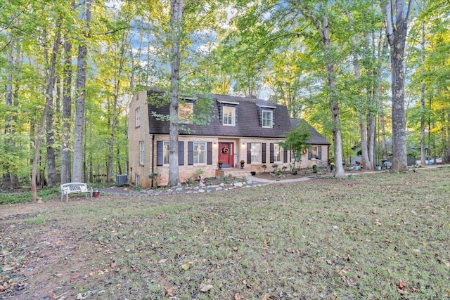 cape cod house featuring a front yard and central AC