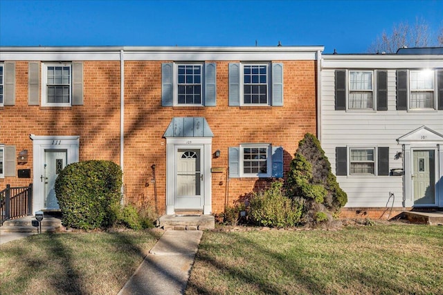 townhome / multi-family property featuring a front lawn