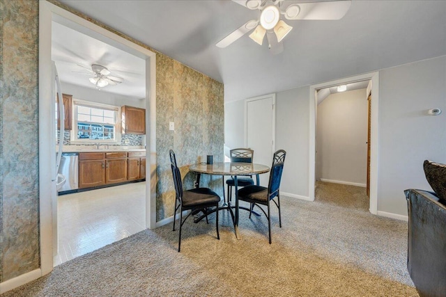 carpeted dining room featuring ceiling fan and sink