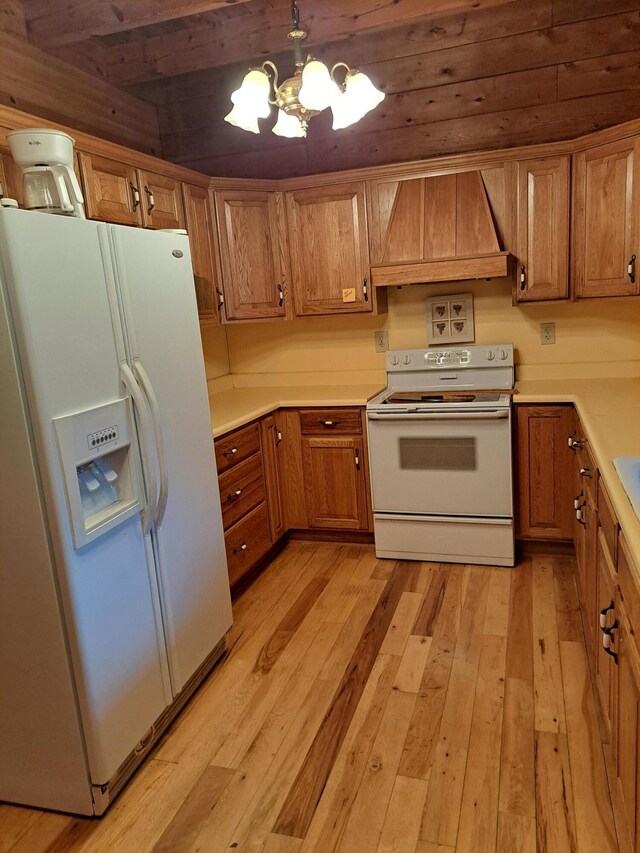 kitchen featuring white appliances, glass insert cabinets, an inviting chandelier, light countertops, and a sink