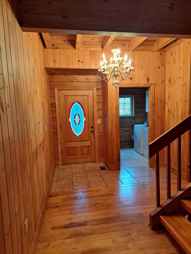 laundry area with visible vents, washing machine and clothes dryer, cabinet space, and wooden walls