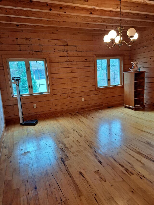 interior space featuring a wealth of natural light, beam ceiling, and light wood-style floors