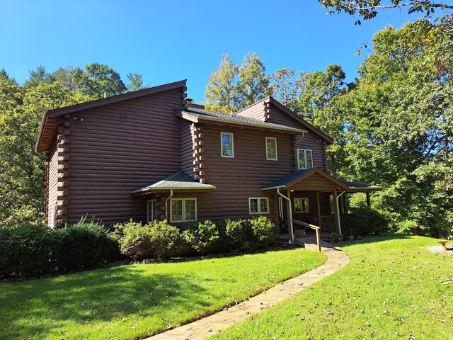 view of side of home with a lawn and log exterior