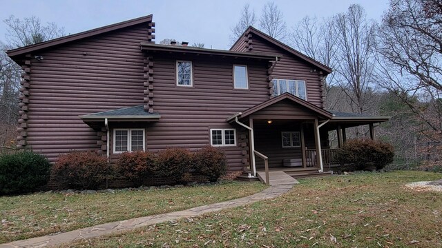 exterior space with log exterior and a lawn