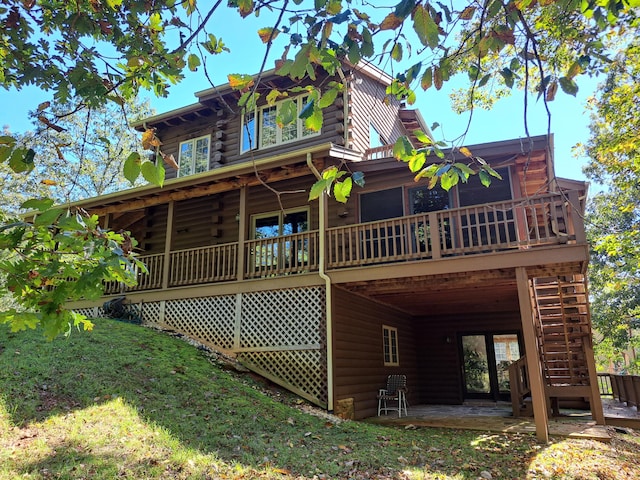 back of property with a wooden deck, stairs, log siding, and a patio