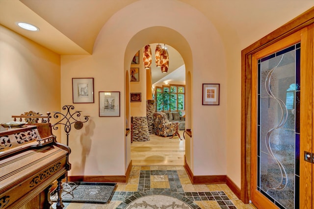 entryway with hardwood / wood-style floors and vaulted ceiling