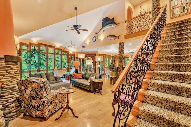 living room with ceiling fan, light hardwood / wood-style floors, and high vaulted ceiling