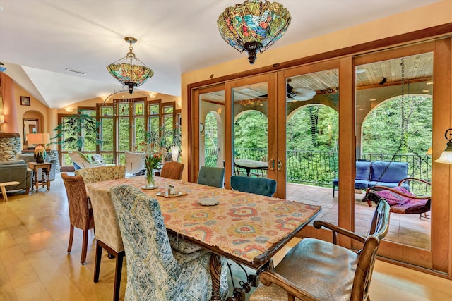 dining room featuring lofted ceiling, plenty of natural light, light hardwood / wood-style floors, and french doors