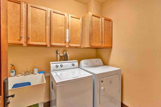 clothes washing area featuring cabinets, washer and clothes dryer, and sink