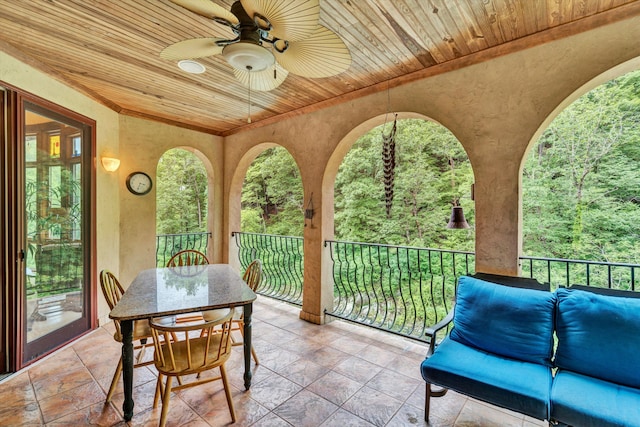 sunroom with ceiling fan and wooden ceiling