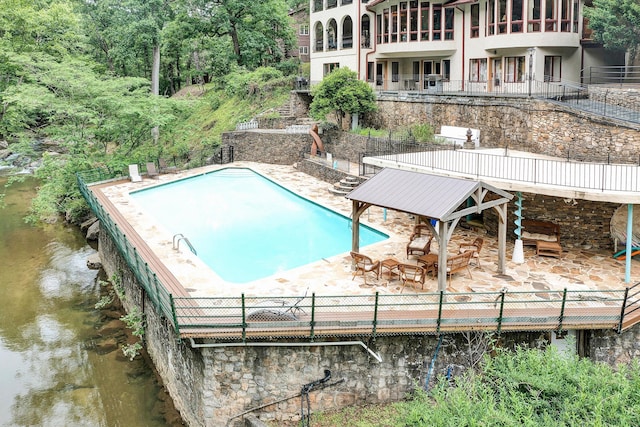 view of swimming pool featuring a patio area and a water view