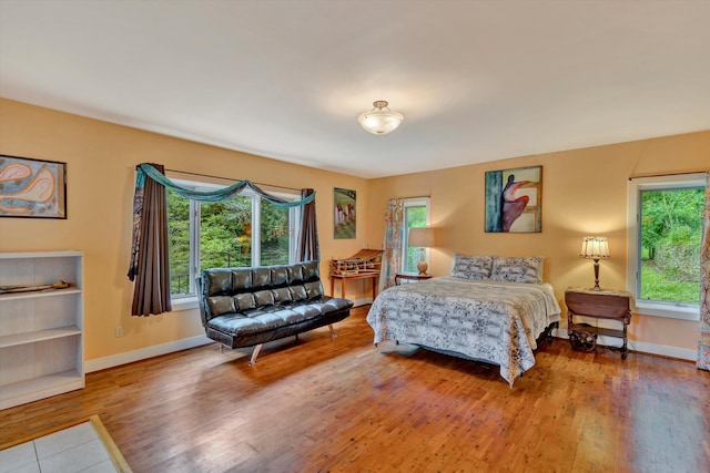 bedroom with hardwood / wood-style floors and multiple windows