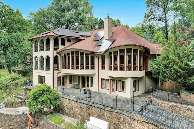 rear view of property with solar panels