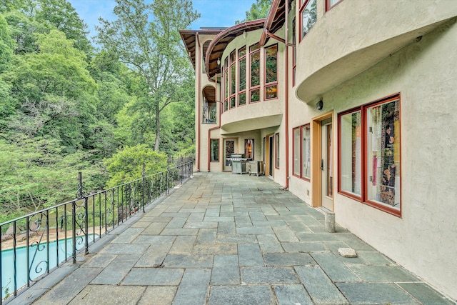 view of patio featuring a fenced in pool and area for grilling