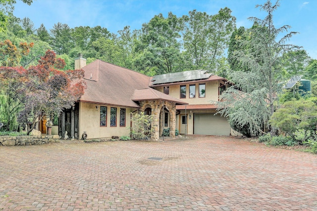 view of front of property with a garage and solar panels