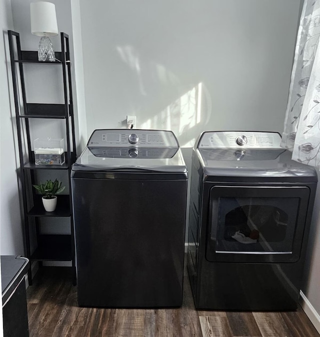 laundry area with dark hardwood / wood-style flooring and washing machine and clothes dryer