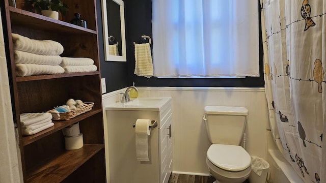 full bathroom featuring toilet, shower / bath combo with shower curtain, and sink