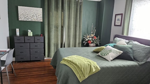 bedroom with dark wood-type flooring