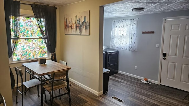 dining area with separate washer and dryer and dark wood-type flooring