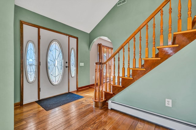 entrance foyer featuring hardwood / wood-style flooring, lofted ceiling, and baseboard heating