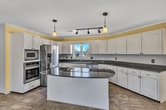 kitchen featuring decorative light fixtures, stainless steel appliances, white cabinetry, and a kitchen island